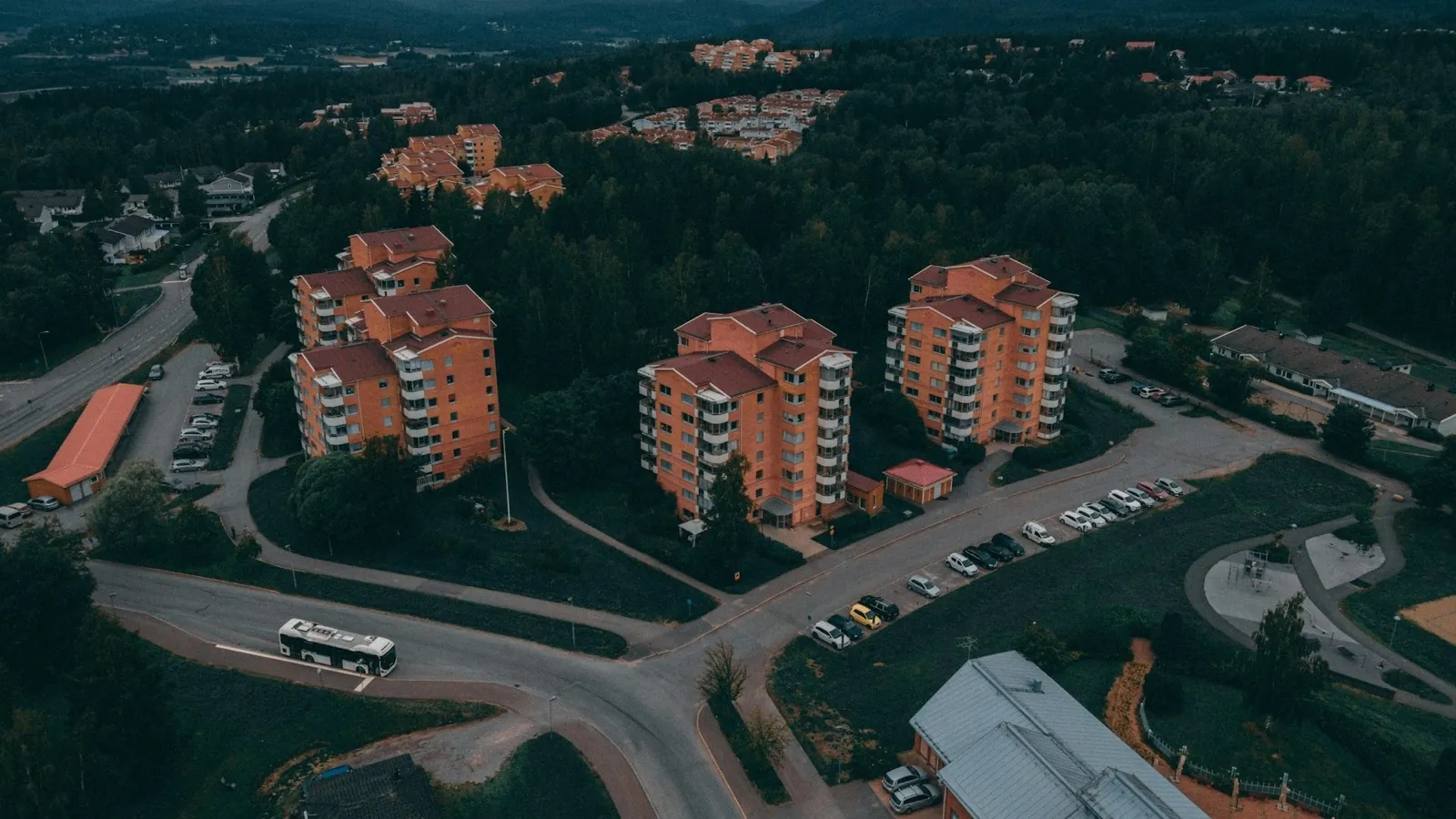 Drönarvy över svenskt hyreshusområde i kvällsljus