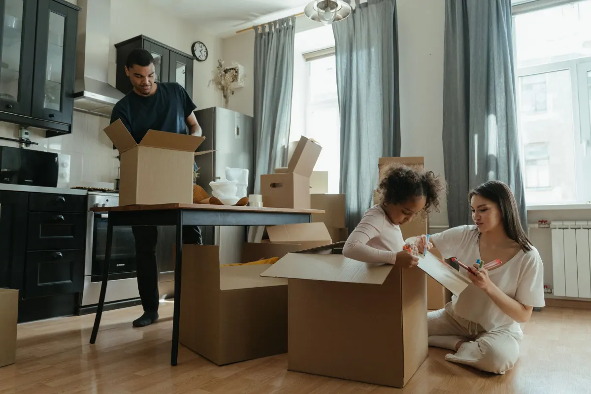 En familj packar upp flyttkartonger i köket i sin nya lägenhet