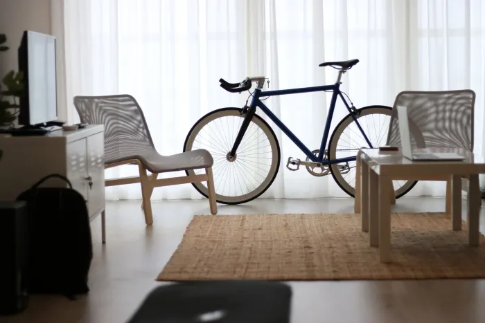 Ljust vardagsrum med två fåtöljer, en cykel och ett soffbord